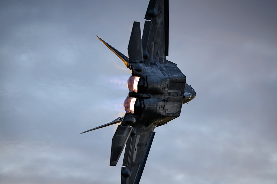 A military fighter jet flies sideways through the air.