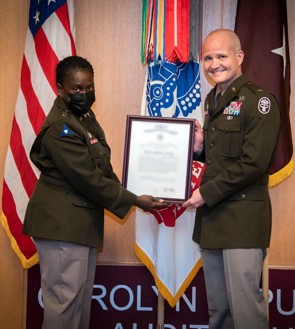 Army Maj. Gen. Telita Crosland, deputy surgeon general, presents Brig. Gen. Clinton Murray, Brooke Army Medical Center commanding general, with a certificate of promotion