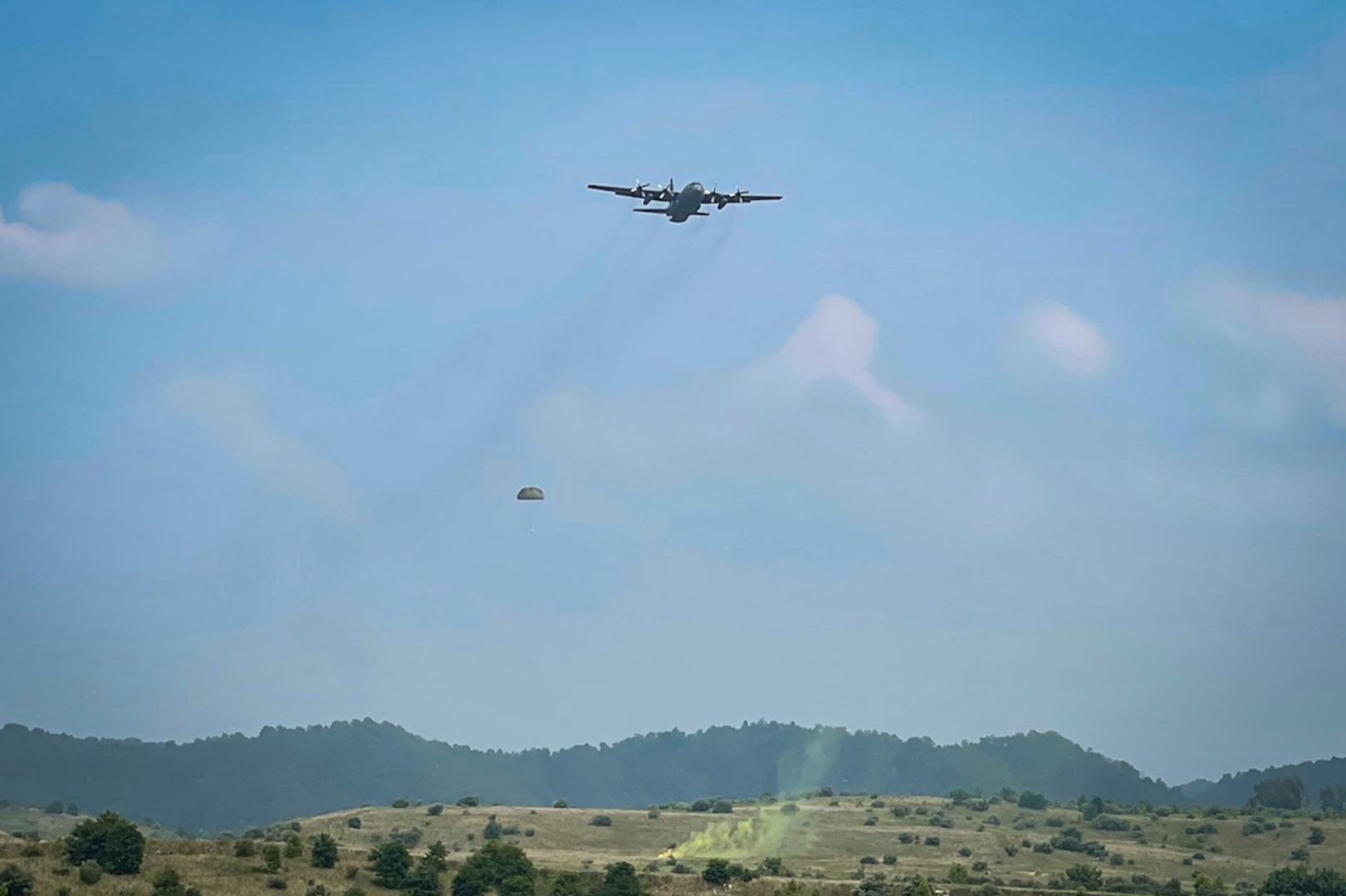 A 103rd Airlift Wing C-130H Hercules aircraft performs a Low Cost Low Altitude airdrop during Exercise Sentry Storm 2021 at Camp Branch, West Virginia, July 20, 2021. Sentry Storm is a joint training environment enabling participants to exercise their skills to prevail over near-peer competitors while applying agile combat employment concepts.
