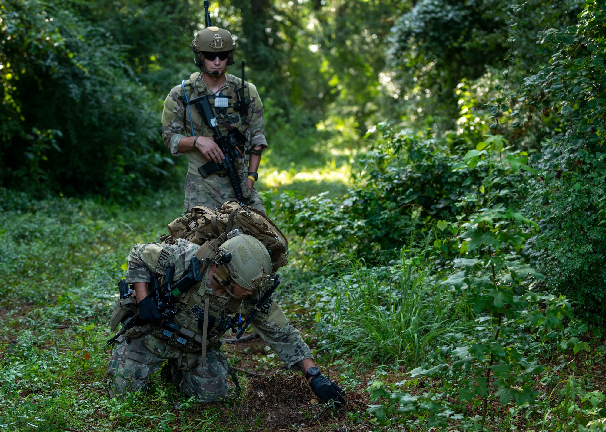 Staff Sgt. Damian Riley, front, 4th Civil Engineer Squadron Explosive Ordnance Disposal technician, and Airman First Class Jarrid McKenzie, 4th CES EOD technician, investigate ground signs during field training exercise Operation Guillotine at Seymour Johnson Air Force Base, July 26, 2021.