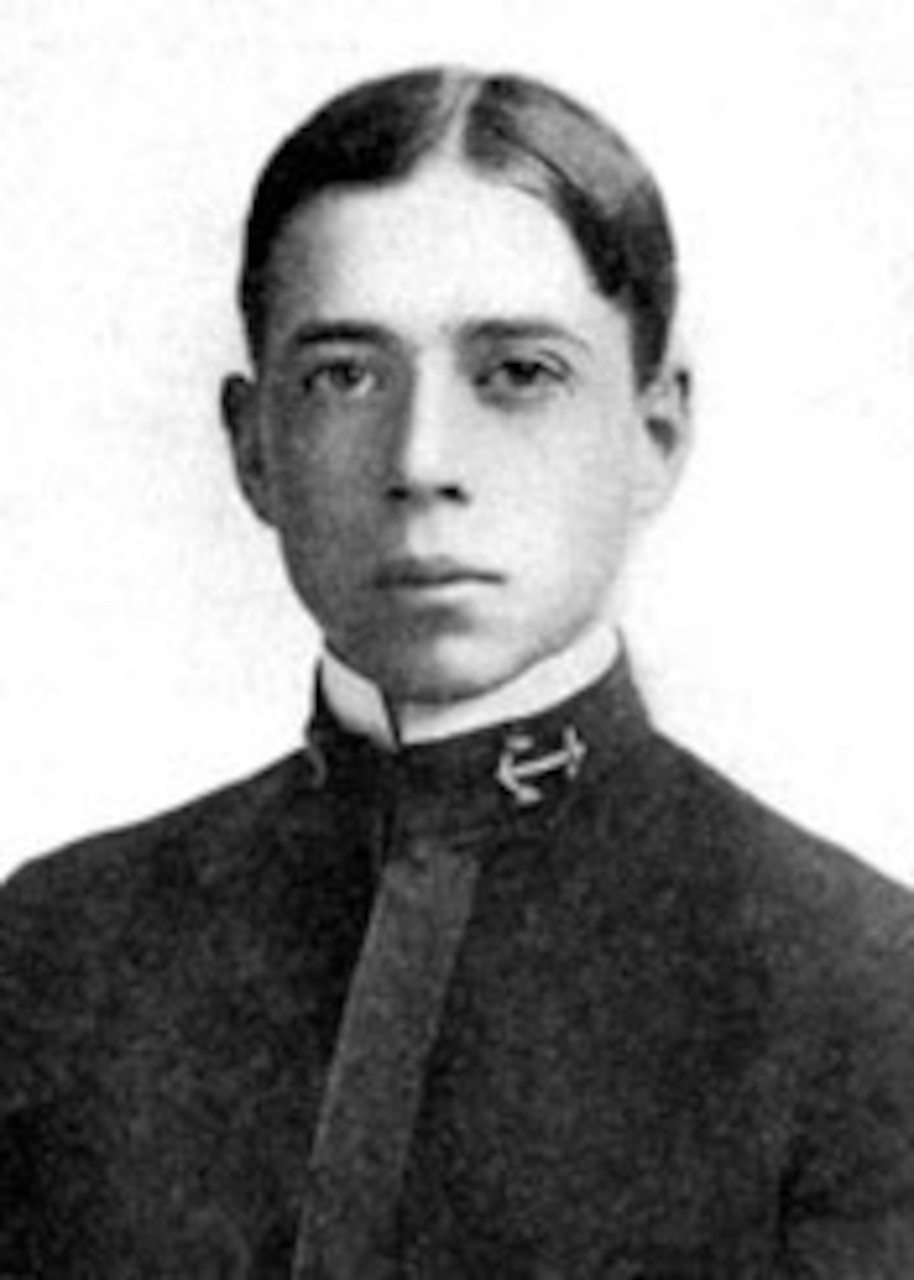 A stoic-looking young man looks at the camera.
