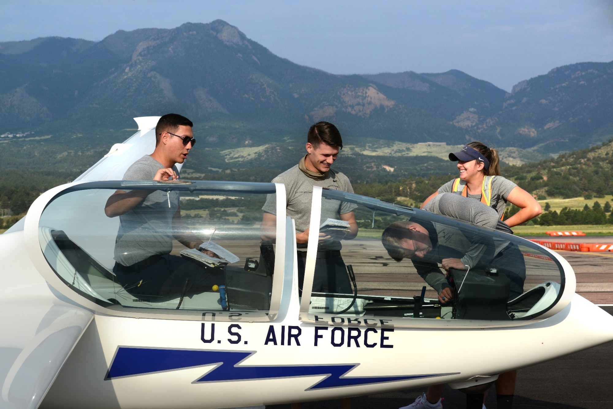 Capt. Brandon Leet, assigned to the 306th Flying Training Squadron, Second Lieutenants Eric Clingenpeel, DJ Alexander and Elizabeth Shaffer, 2021 graduates of the Air Force Academy, complete safety checks on a glider.