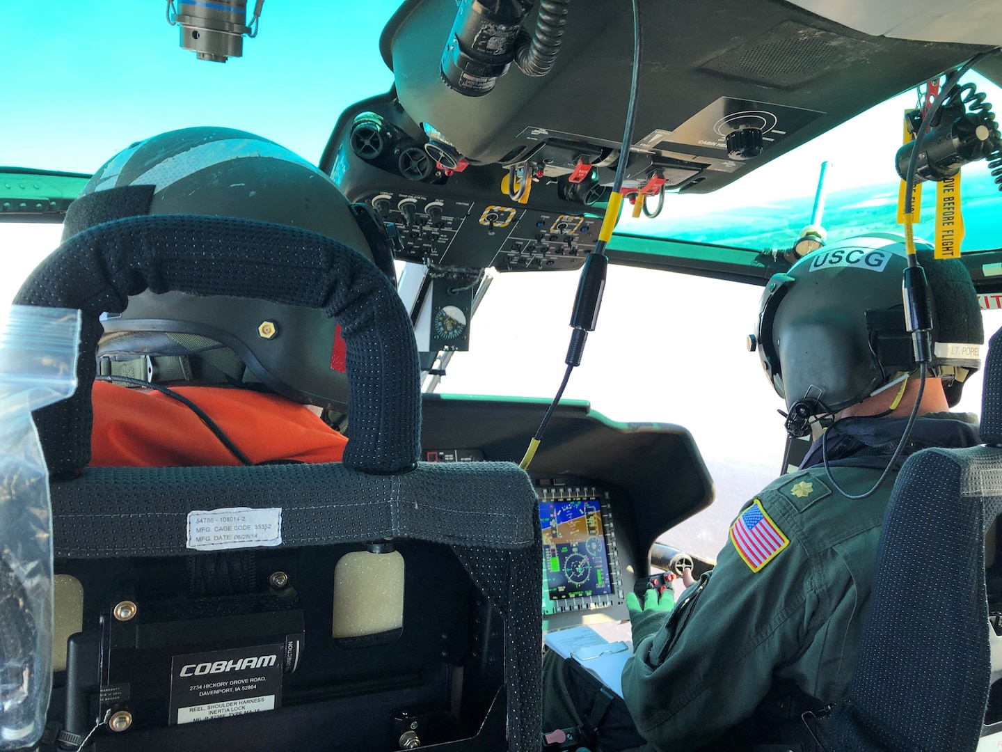 CDR Ryan Popiel flies Rear Adm. Nathan Mooreon the upgraded MH-65E helicopter.