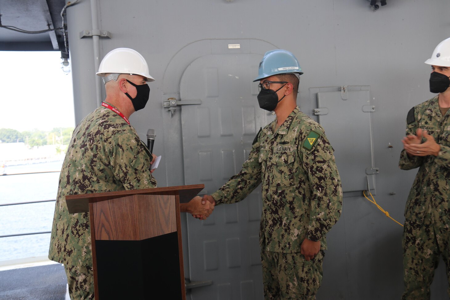 Rear Adm. Brendan McLane, left, commander, Naval Surface Force Atlantic, shakes hands with Machinist’s Mate 2nd Class John Henry Soliman before presenting the Navy Unit Commendation to the crew of the guided-missile destroyer USS James E. Williams (DDG 95). James E. Williams received the award for its 2020 deployment to the U.S. 5th and 6th Fleet areas of operation. (U.S. Navy photo by Logistics Specialist Seaman Savannah Sellner)