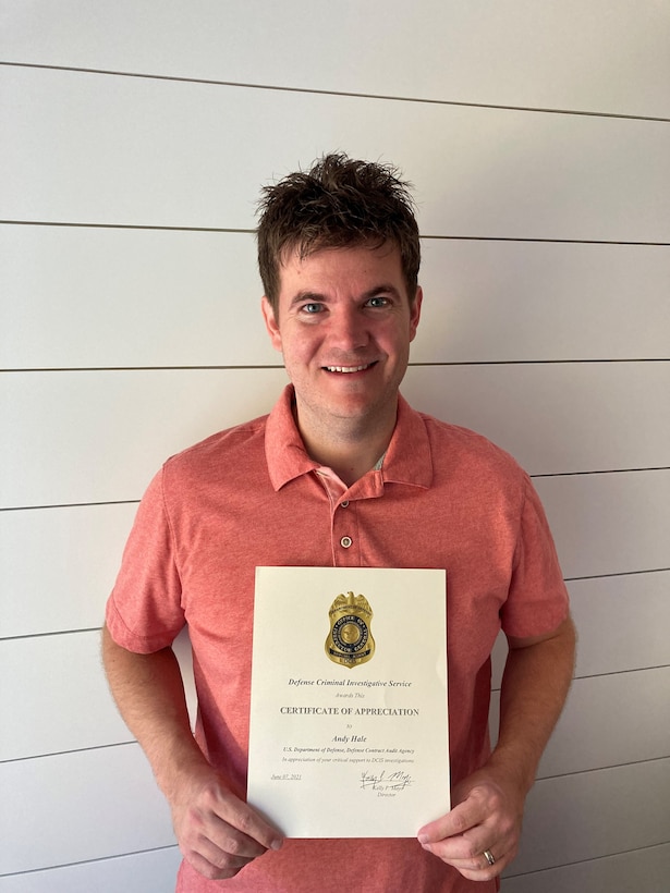 man in orange shirt holding certificate