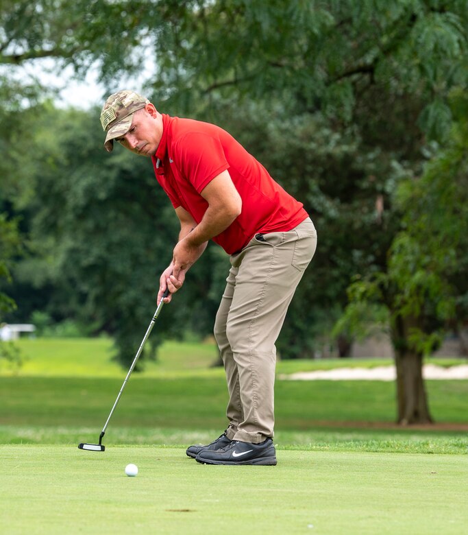 Tech. Sgt. Nathaniel Correll, 436th Maintenance Squadron Isochronal Maintenance Dock noncommissioned officer in charge of ISO jets, completes his putt during an intramural golf match at the Eagle Creek Golf Course on Dover Air Force Base, Delaware, August 3, 2021. Eight intramural golf teams are finishing up the regular season and preparing for playoffs in September. (U.S. Air Force photo by Tech. Sgt. Nicole Leidholm)