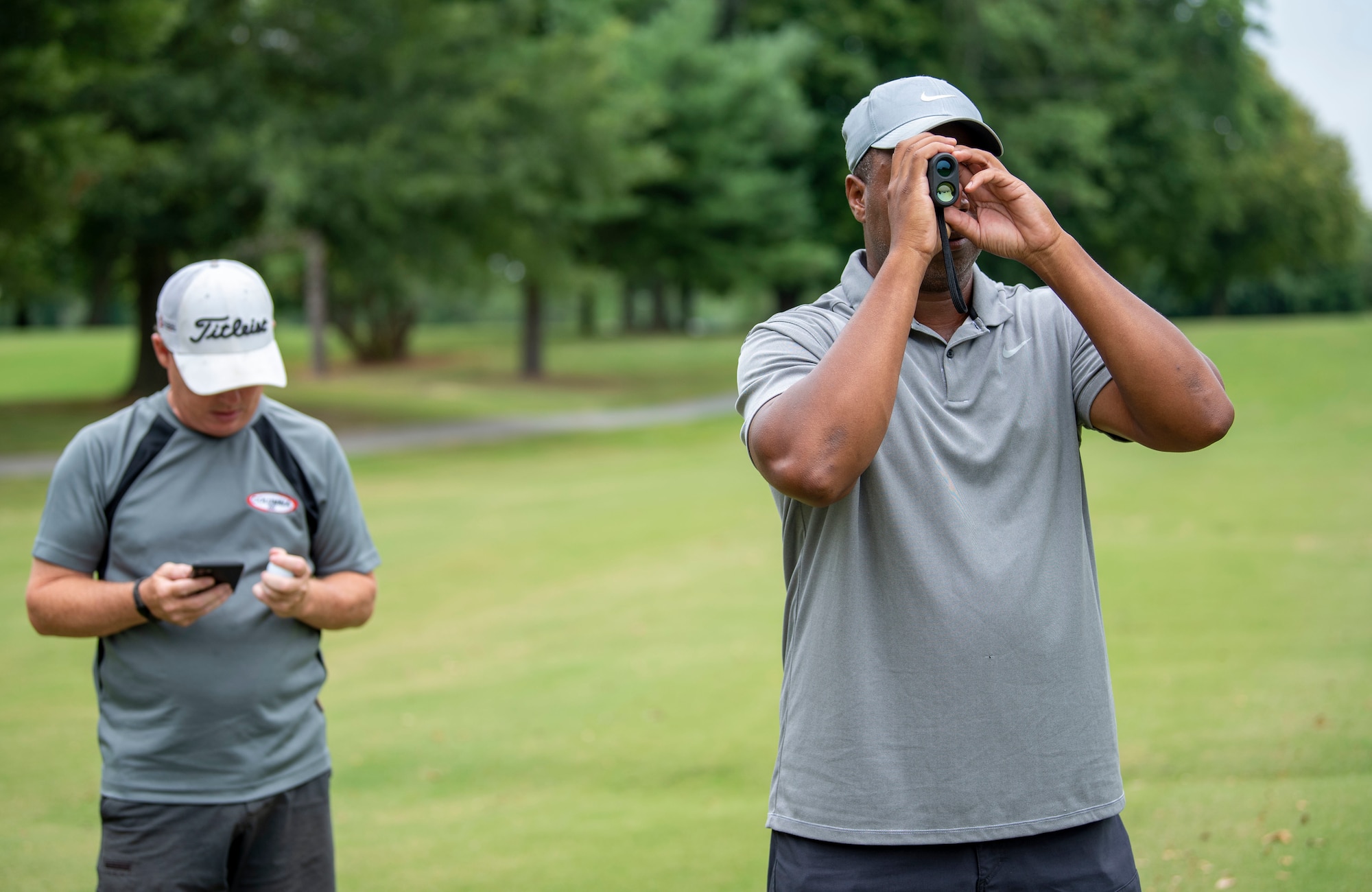 Alton Robinson, right, 436th Force Support Squadron Eagle Lanes youth bowling coach, and Steven Weber, 436th FSS Eagle Lanes manager, calculate the yardage to the putting green during an intramural golf match at the Eagle Creek Golf Course on Dover Air Force Base, Delaware, August 3, 2021. Eight intramural golf teams are finishing up the regular season and preparing for playoffs in September. (U.S. Air Force photo by Tech. Sgt. Nicole Leidholm)