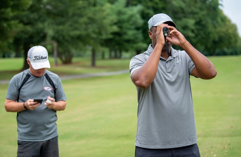 Alton Robinson, right, 436th Force Support Squadron Eagle Lanes youth bowling coach, and Steven Weber, 436th FSS Eagle Lanes manager, calculate the yardage to the putting green during an intramural golf match at the Eagle Creek Golf Course on Dover Air Force Base, Delaware, August 3, 2021. Eight intramural golf teams are finishing up the regular season and preparing for playoffs in September. (U.S. Air Force photo by Tech. Sgt. Nicole Leidholm)