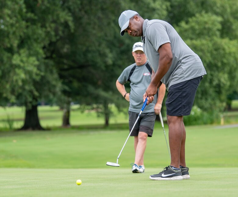 Alton Robinson, right, 436th Force Support Squadron Eagle Lanes youth bowling coach, putts during an intramural golf match at the Eagle Creek Golf Course on Dover Air Force Base, Delaware, August 3, 2021. Eight intramural golf teams are finishing up the regular season and preparing for playoffs in September. (U.S. Air Force photo by Tech. Sgt. Nicole Leidholm)