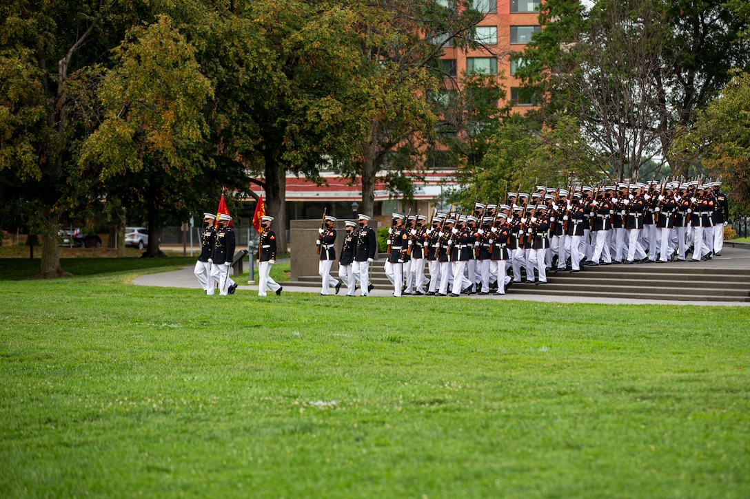 Marines with Marine Barracks Washington march into formation during the Tuesday Sunset Parade at the Marine Corps War Memorial, Arlington, Va., Aug. 3, 2021.