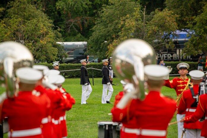 Marines with the parade staff march onto the field during the Tuesday Sunset Parade at the Marine Corps War Memorial, Arlington, Va., Aug. 3, 2021.