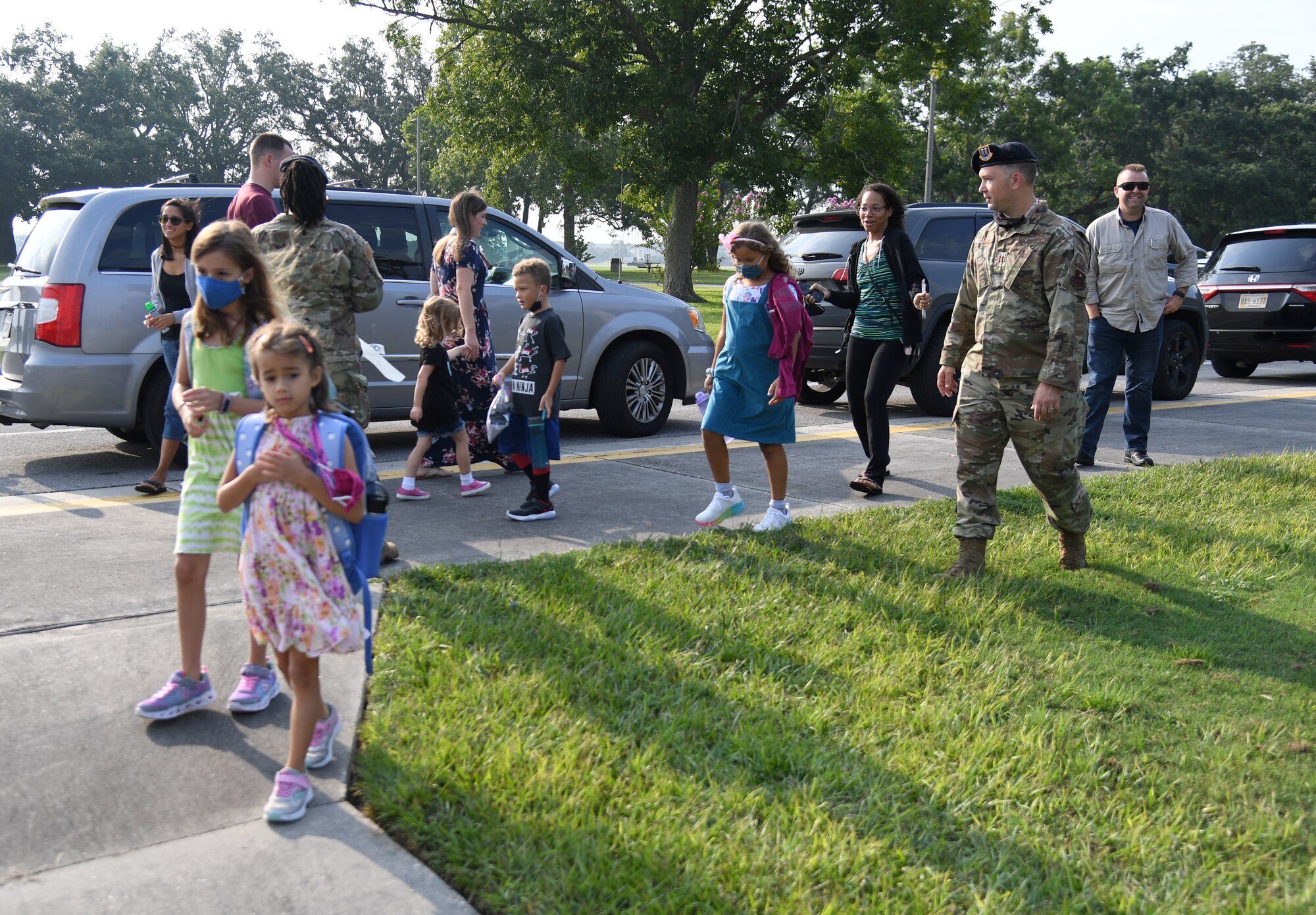 Members of the 81st Security Forces Squadron greet military families for the first day of school near the pedestrian gate at Keesler Air Force Base, Mississippi, Aug. 4, 2021. Defenders and their mascot welcomed the children with stickers as they went to Jeff Davis Elementary School. (U.S. Air Force photo by Kemberly Groue)