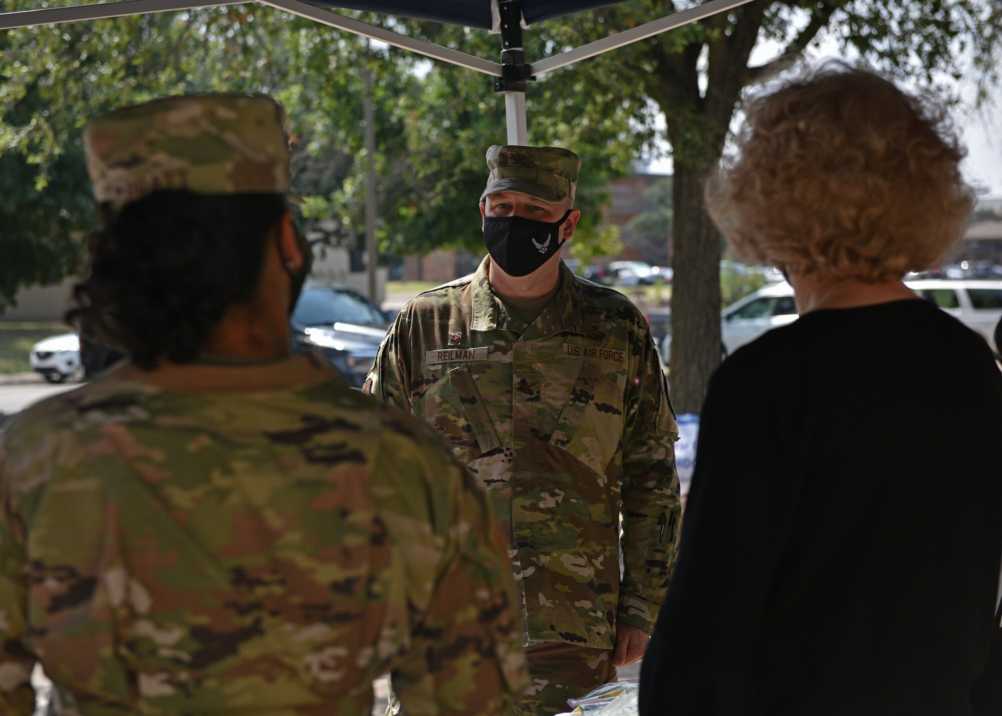 U.S. Air Force Col. Matthew Reilman, 17th Training Wing commander, speaks to volunteers while waiting for cars at the Back to School Backpack Event Operation Homefront on Goodfellow Air Force Base, Texas, Aug. 4, 2021. The Goodfellow first sergeants gathered roughly $1,000 worth of school supplies donated for Operation Homefront. (U.S. Air Force photo by Senior Airman Ashley Thrash)