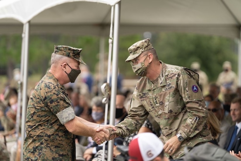 (right) U.S. Army Central outgoing Commanding General, Lt. Gen. Terry Ferrell, shakes the U.S. Central Command's Commander, Marine Corps Gen. Kenneth McKenzie's hand after his remarks during USARCENT's Change of Command ceremony at Patton Hall's Lucky Park on Shaw Air Force Base, S.C., Aug. 4, 2021. Mckenzie officiated the ceremony for CENTCOM's Army Service Component Command. (U.S. Army photo by Sgt. Leo Jenkins)