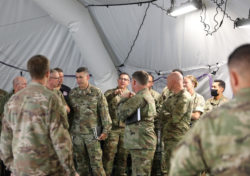 U.S. Army Reserve Col. Straus M. Scantlin (center), director of the Strategic Initiatives Group (SIG) for the U.S. Army Civil Affairs and Psychological Operations Command (Airborne), engages in discussion while participating in the Joint Warfighting Assessment 2021 distinguished visitor day, at Fort Carson, Colo., June 25, 2021. USACAPOC(A) Civil Affairs, Psychological Operations and Information Operations Soldiers took part in JWA 2021 with participants from different Army units and multinational partners such as U.K., Australian and Canadian armed forces, working to improve interoperability between U.S. joint forces and our allies. JWA exercises help the Army evaluate emerging concepts, integrate new technologies, and promote interoperability between the Army, other services, and our multinational partners. Joint and multinational partners are key to the success of Multi-Domain Operations.