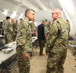 Brig. Gen. Gen. Jeffrey C. Coggin (left), commanding general of the U.S. Army Civil Affairs and Psychological Operations Command (Airborne), speaks with Maj. Gen. Matthew McFarlane, commanding general, 4th Infantry Division, as they participate in the Joint Warfighting Assessment 2021 distinguished visitor day initial briefing at Fort Carson, Colo., June 25, 2021. U.S. Army Civil Affairs and Psychological Operations Command (Airborne) Civil Affairs, Psychological Operations, and Information Operations Soldiers took part in JWA 2021 with participants from different Army units and multinational partners such as U.K., Australian and Canadian armed forces, working to improve interoperability between U.S. joint forces and our allies. JWA exercises help the Army evaluate emerging concepts, integrate new technologies, and promote interoperability between the Army, other services and, our multinational partners. Joint and multinational partners are key to the success of Multi-Domain Operations.