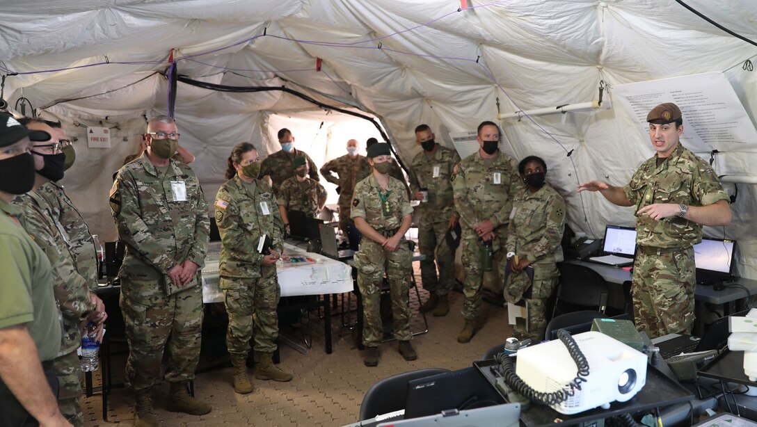 Brig. Gen. Gen. Jeffrey C. Coggin (left), commanding general of the U.S. Army Civil Affairs and Psychological Operations Command (Airborne), Lt. Gen. Jody J. Daniels (right), Chief of Army Reserve and Commanding General, U.S. Army Reserve Command, receive an exercise brief from members of the 1st Armored Infantry Brigade (United Kingdom) as they participate in the Joint Warfighting Assessment 2021 distinguished visitor day at Fort Carson, Colo., June 25, 2021. U.S. Army Civil Affairs and Psychological Operations Command (Airborne) Civil Affairs, Psychological Operations, and Information Operations Soldiers took part in JWA 2021 with participants from different Army units and multinational partners such as U.K., Australian and Canadian armed forces, working to improve interoperability between U.S. joint forces and our allies. JWA exercises help the Army evaluate emerging concepts, integrate new technologies, and promote interoperability between the Army, other services, and our multinational partners. Joint and multinational partners are key to the success of Multi-Domain Operations.