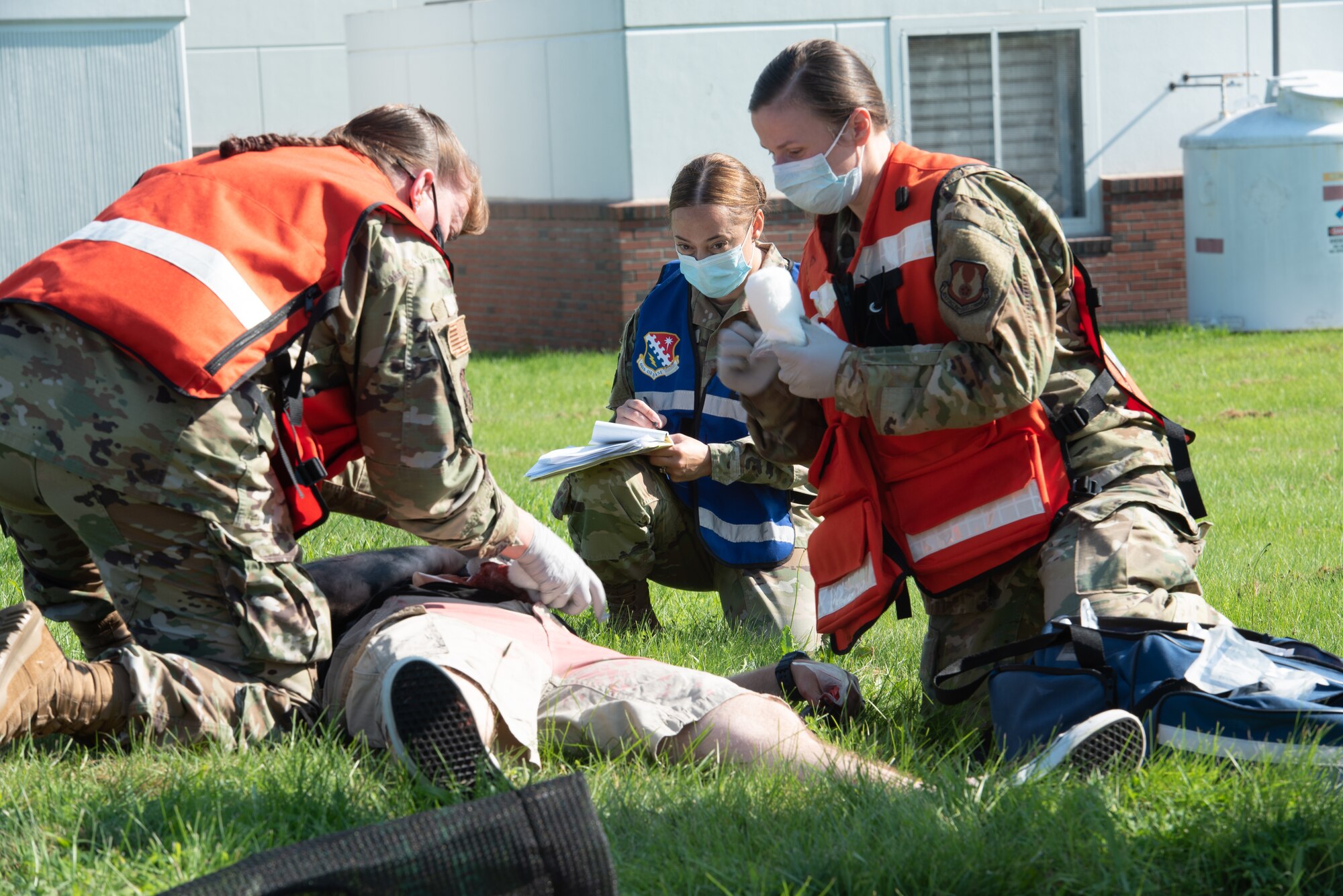 Maj. Andrea Tidd, left, 66th Medical Squadron Field Response Team chief, and Tech Sgt. Tatiana Lieback, 66 MDS Field Response Team member, provide support to a simulated victim during a Ready Eagle exercise at Hanscom Air Force Base, Mass., July 30, while Maj. Stela Strilagas, Inspection Team member, looks on. The full-scale disaster response exercise tested Hanscom medics on their response to a chemical, biological, radiological, nuclear, or explosive event. (U.S. Air Force photo by Todd Maki)