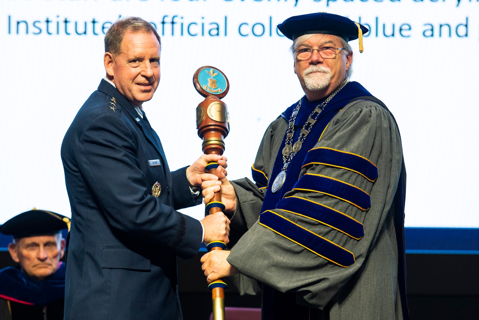 Lt. Gen. James Hecker, Air University commander and president, passes the Air Force Institute of Technology mace to Walter Jones as he accepts the role of director and chancellor during a ceremony July 27 at Wright-Patterson Air Force Base. Jones is the 50th AFIT leader and only the second civilian. (U.S. Air Force photo by Wesley Farnsworth)