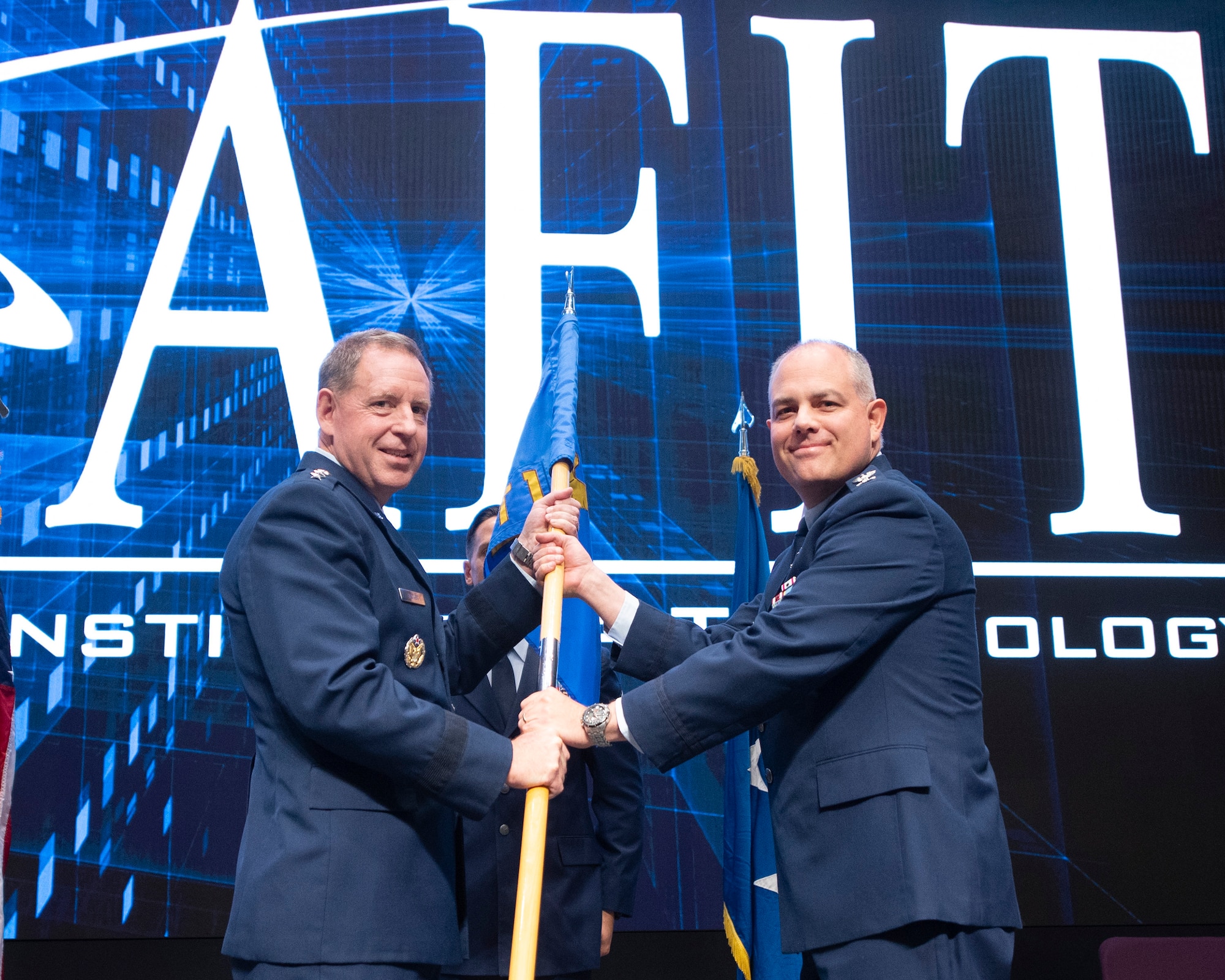 Lt. Gen. James Hecker (left), Air University commander and president, presents the Air University Detachment 1 (Air Force Institute of Technology) guidon to Col. Paul Harmer during a change-of-command ceremony July28 at the AFIT campus on Wright-Patterson Air Force Base. Harmer assumes command from Col. Paul Cotellesso, who retired after 30 years of military service. (U.S. Air Force photo by R.J. Oriez)