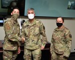 Army General Paul Nakasone shakes hands with man in uniform.