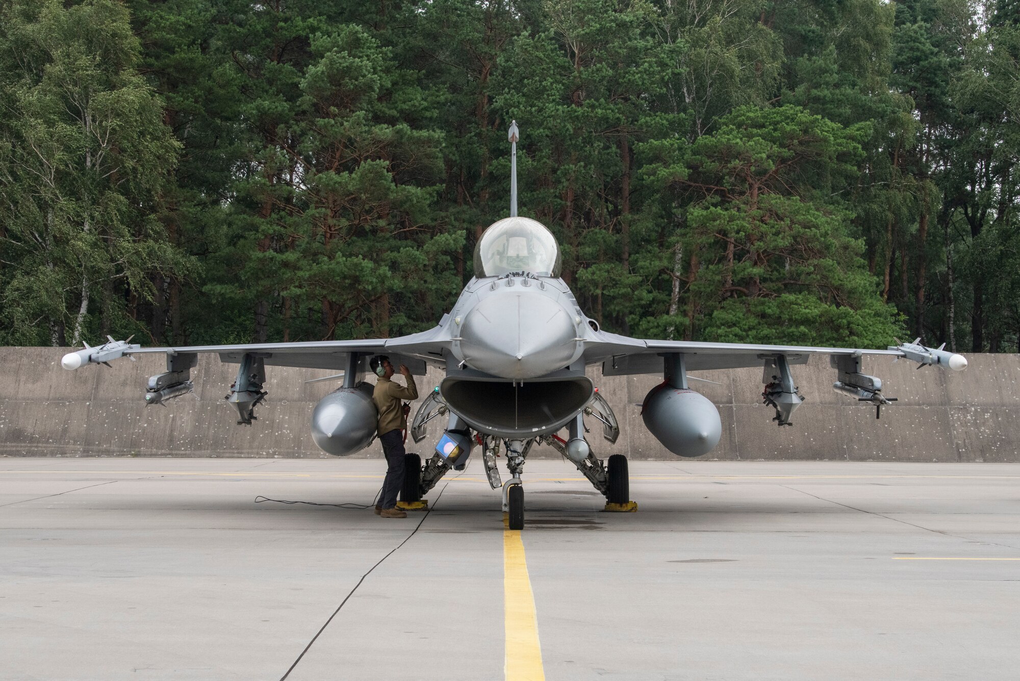 U.S. Air Force Senior Airman Peter Ho, 480th Expeditionary Fighter Squadron crew chief, conducts a pre-flight check of a U.S. Air Force F-16 Fighting Falcon at Łask Air Base, Poland, August 2, 2021. U.S. Air Force F-16 Fighting Falcons and support personnel are in Poland to participate in Aviation Detachment Rotation 21.3. (U.S. Air Force photo by Tech. Sgt. Anthony Plyler)