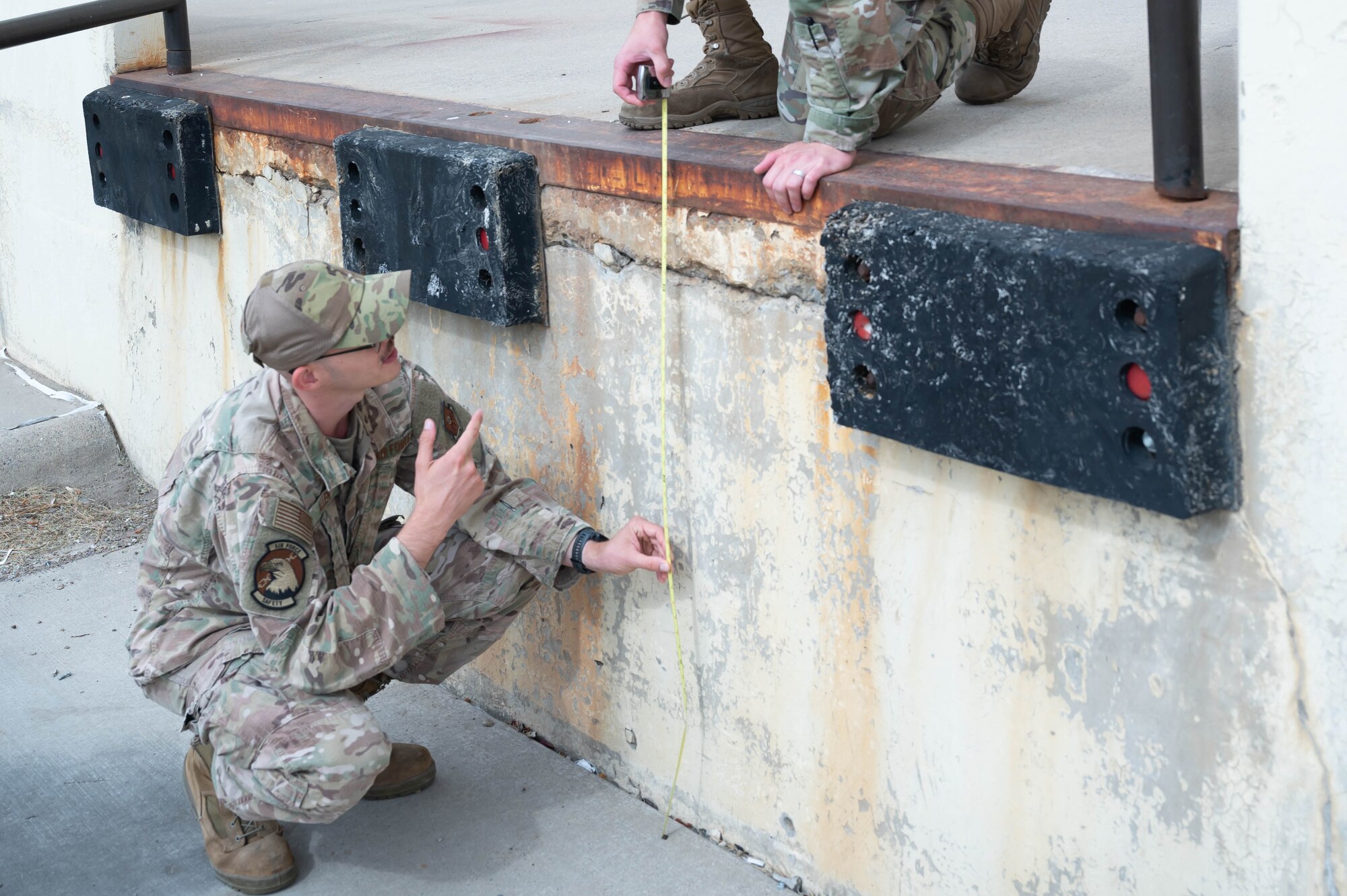 Tech. Sgt. Mark Allen, 341st Missile Wing occupational safety NCO in charge, holds a measuring tape to inspect the height of a loading dock Aug. 2, 2021 at Malmstrom Air Force Base, Mont.