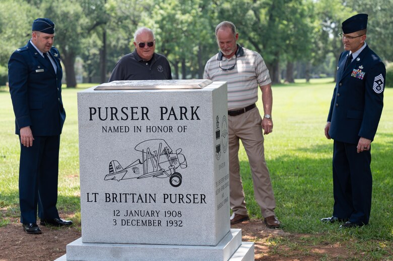 Col. Mark Dmytryszyn, left, 2nd Bomb Wing commander, and Chief Master Sgt. Travis Chadick, right, 2nd Bomb Wing command chief, observe the Purser Park Monument with descendents of Lt. Brittain Purser during the Pursuer Park Monument unveiling ceremony at Barksdale Air Force Base, Louisiana, July 30, 2021. The monument was memorialized in front of Commander's Square park. (U.S. Air Force photo by Airman 1st Class Jonathan E. Ramos)
