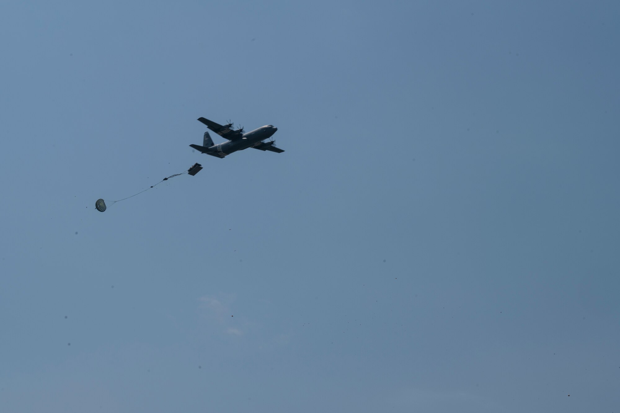 A U.S. Air Force C-130J Super Hercules aircraft drops heavy cargo onto a dropzone during exercise Agile Spirit 21
