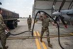 A man moves a fuel hose