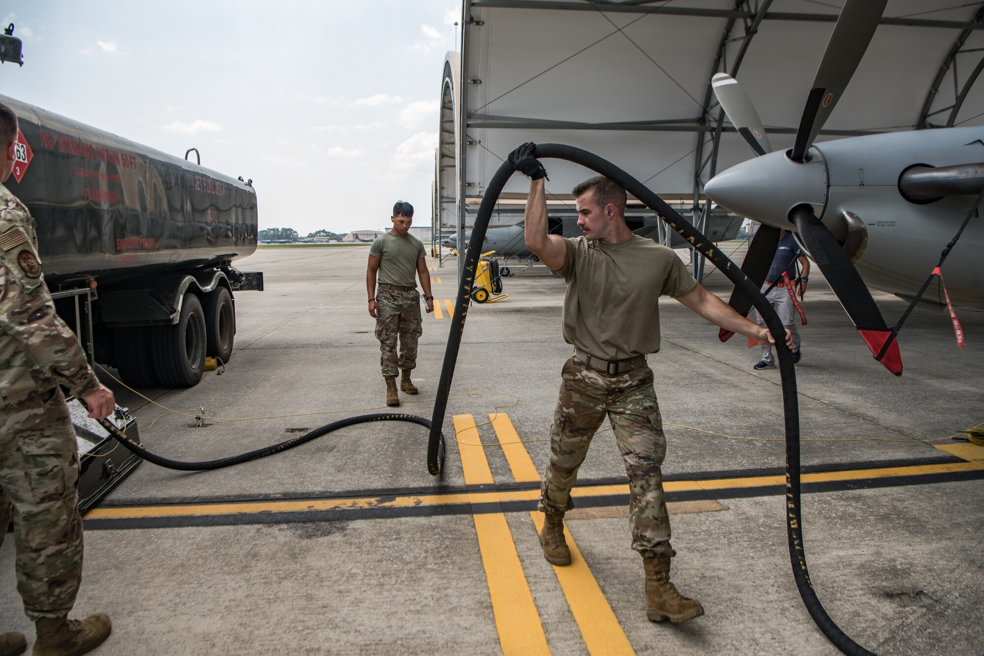 A man moves a fuel hose