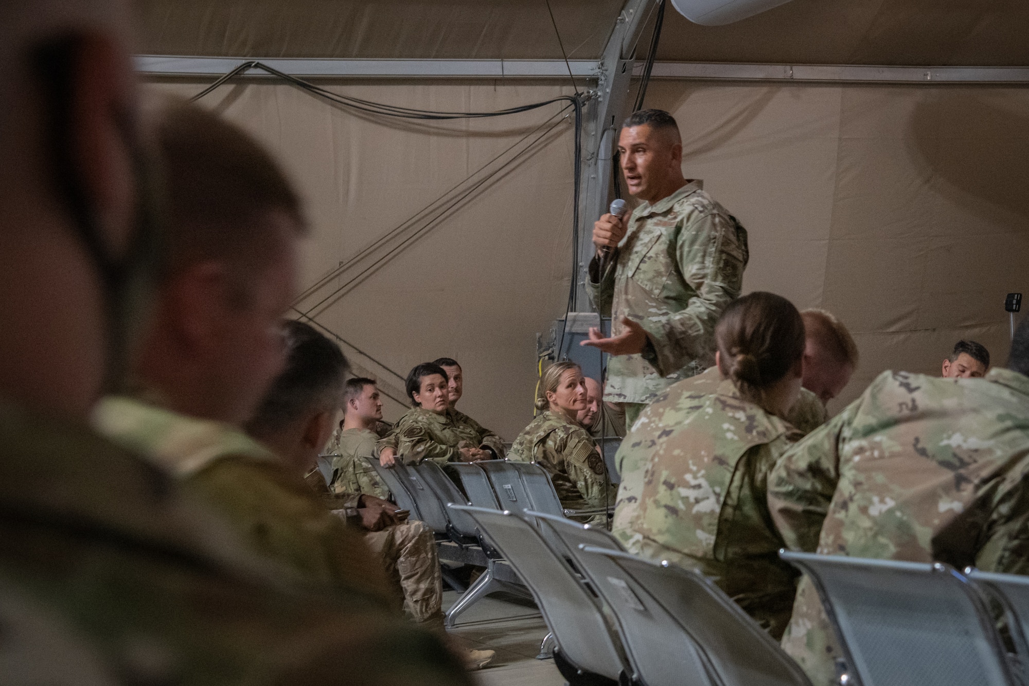 U.S. Air Force Chief Master Sgt. Jose Diaz, 378th Expeditionary Medical Group superintendent, briefs personnel who just arrived at Prince Sultan Air Base, Kingdom of Saudi Arabia, during a Right Start briefing in the U.S. Passenger Terminal, July 12, 2021.