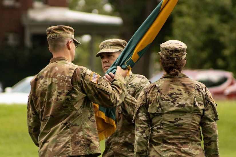 U.S. Army Reserve Col. Franklin J. Estes, incoming commander for the 151st Theater Information Operations Group, accepts the unit colors from U.S. Army Reserve Lt. Col. Jonathan P. Berliner, commander, 303rd Information Operations Army Service Component Command Support Detachment, during the change of command at Fort Totten, New York, July 18, 2021 (U.S. Army Reserve photo by Spc. Sean P. O'Hara, 151 Theater Information Operations Group).