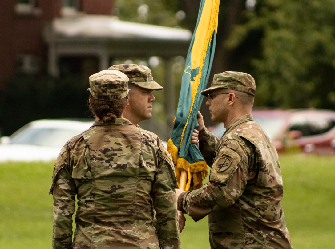 U.S. Army Reserve Col. Franklin J. Estes, incoming commander for the 151st Theater Information Operations Group, returns the unit colors to acting TIOG command sergeant major, U.S. Army Reserve Command Sgt. Maj. Troy A. Hershberger, during the change of command at Fort Totten, New York, July 18, 2021.