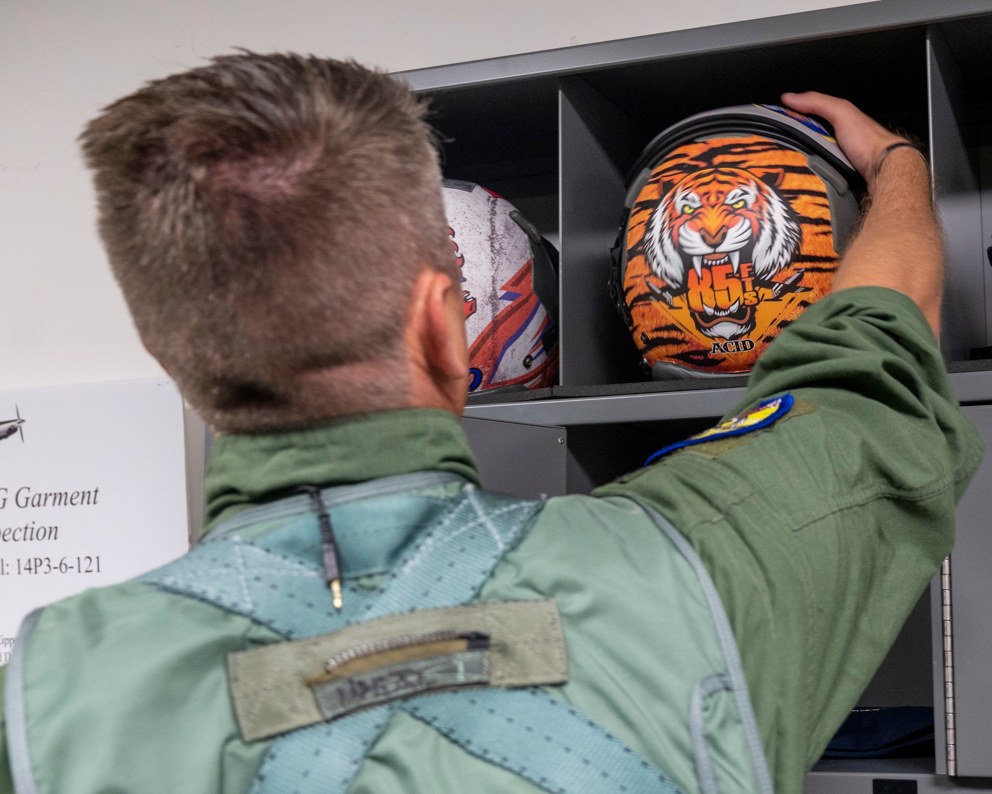 U.S. Air Force Lt. Col. Brian “Tiger King” Tripp, 85th Flying Training Squadron commander, grabs his flight helmet on Tiger Day before his flight at Laughlin Air Force Base, Texas on August 5, 2021. Pilots on Tiger Day took to the sky to celebrate their heritage for being a part of the 85th Flying Training Squadron in a competition against fellow instructor pilots. (U.S. Air Force Photo by Senior Airman Nicholas Larsen)