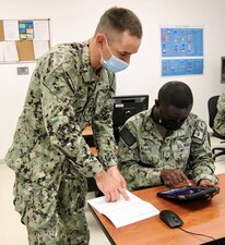 LEMOORE, Calif. -- (Aug. 5, 2021) Aviation Structural Mechanic First Class Jacob Schmid, Center for Naval Aviation Technical Training Unit (CNATTU) Lemoore instructor, reviews training materials with Aviation Electrician’s Mate 3rd Class Enock Asare. Schmid provided subject-matter expertise to the team that’s developing the corrosion control application prototype being used at the CNATTU Lemoore to help students retain knowledge on how to identify and control corrosion on aircraft. (U.S. Navy photo)