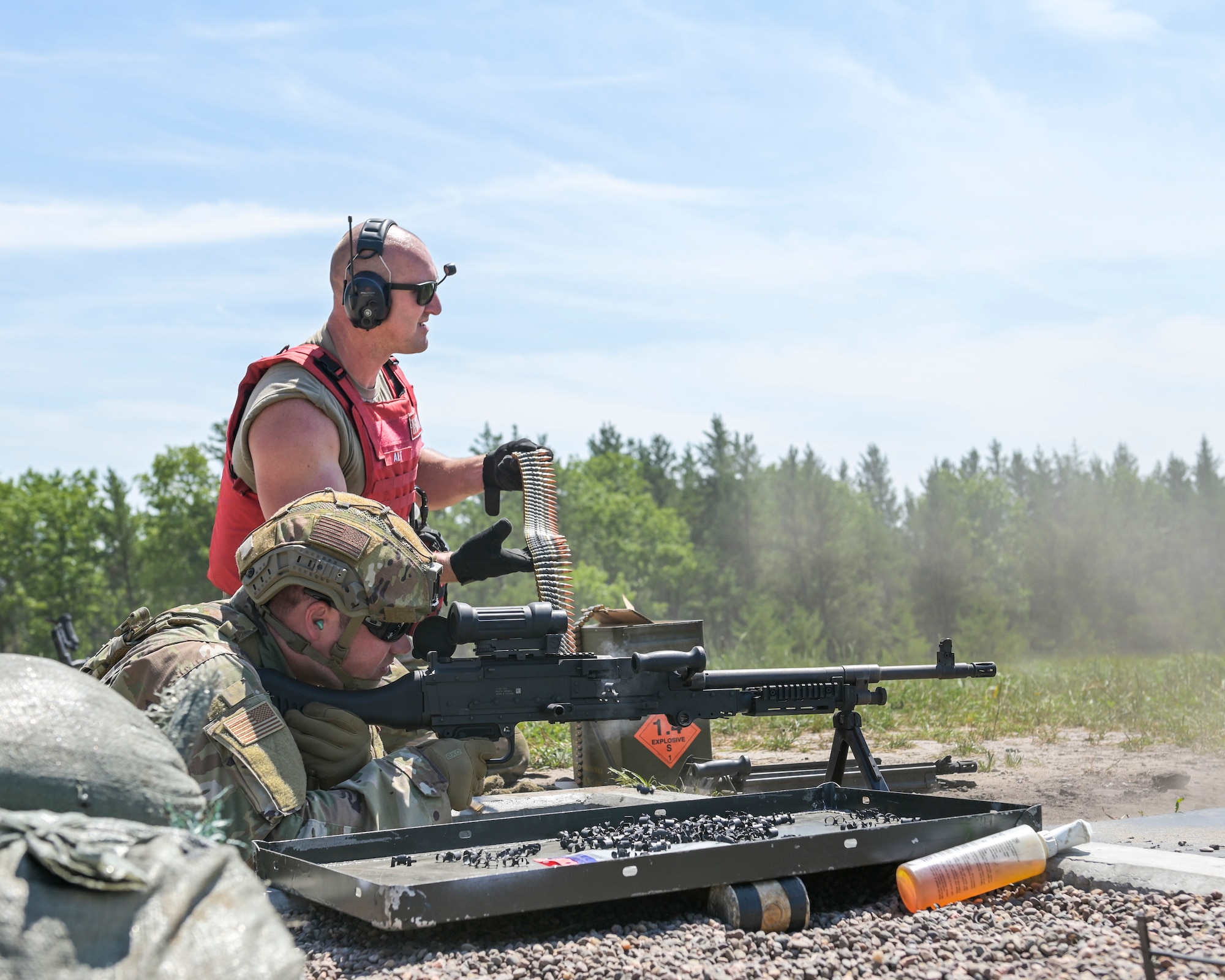 U.S. Air Force Tech. Sgt. James Alt supports U.S. Air Force Tech. Sgt. Chase Kenimer, both security forces Airmen assigned to the 115th Security Forces Squadron, Truax Field, Madison, Wisconsin, while shooting an M240B Machine Gun during Audacious Warrior July 25, 2021 at Fort McCoy, Wisconsin. Whether down range or at home, Security Forces and Explosive Ordnance Disposal teams work closely together making this joint training beneficial for the overall mission. (U.S. Air National Guard photo by Staff Sgt. Cameron Lewis)