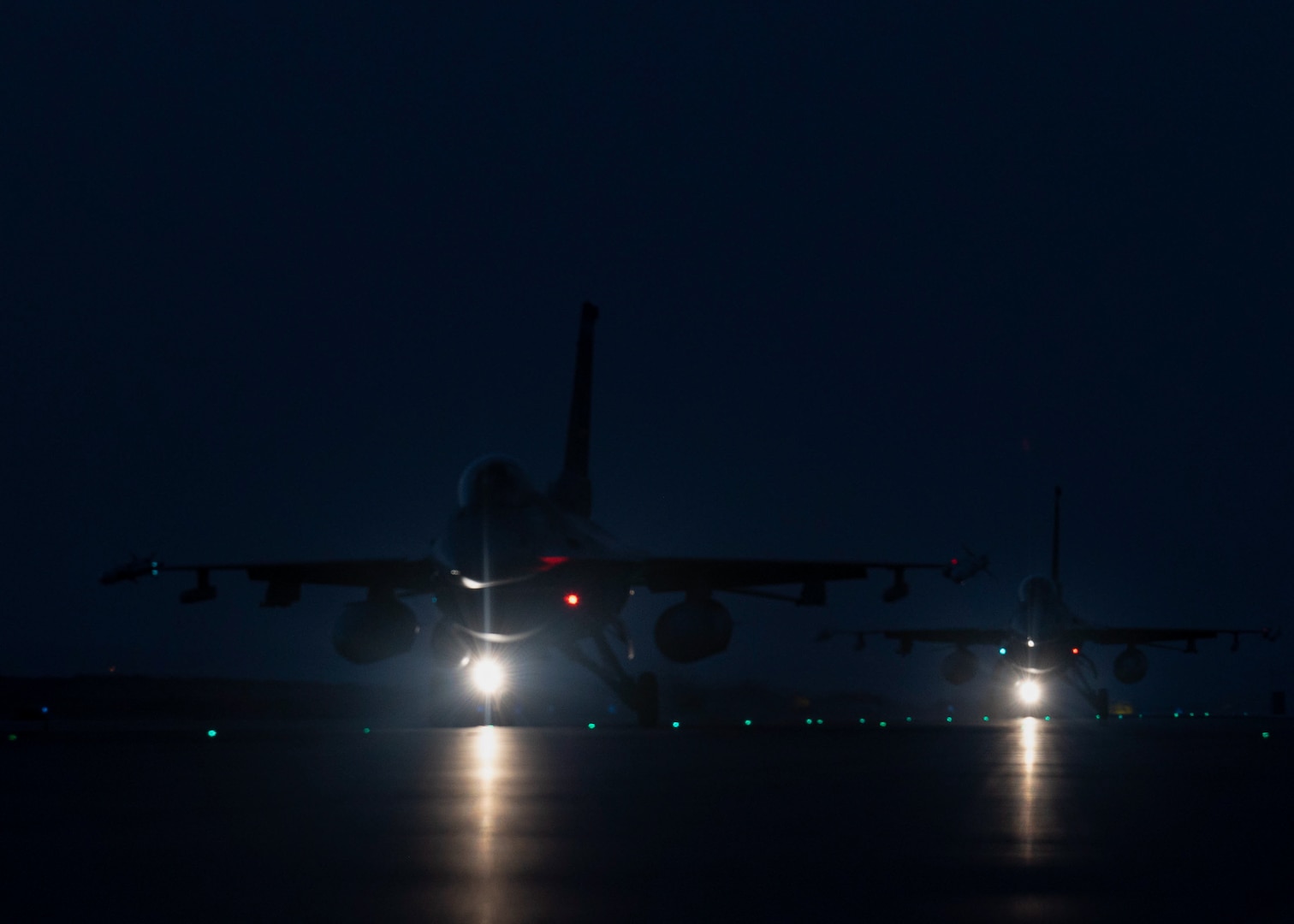 Two U.S. Air Force F-16 Fighting Falcons taxi on the runway at Prince Sultan Air Base, Kingdom of Saudi Arabia, after participating in a combined counter-unmanned aerial systems training operation with Royal Saudi aircraft, July 29, 2021. The event was part of an ongoing series of integration missions between U.S. Air Force Central and partner nations to ensure the security and stability of regional airspace. (U.S. Air Force photo by Senior Airman Samuel Earick)