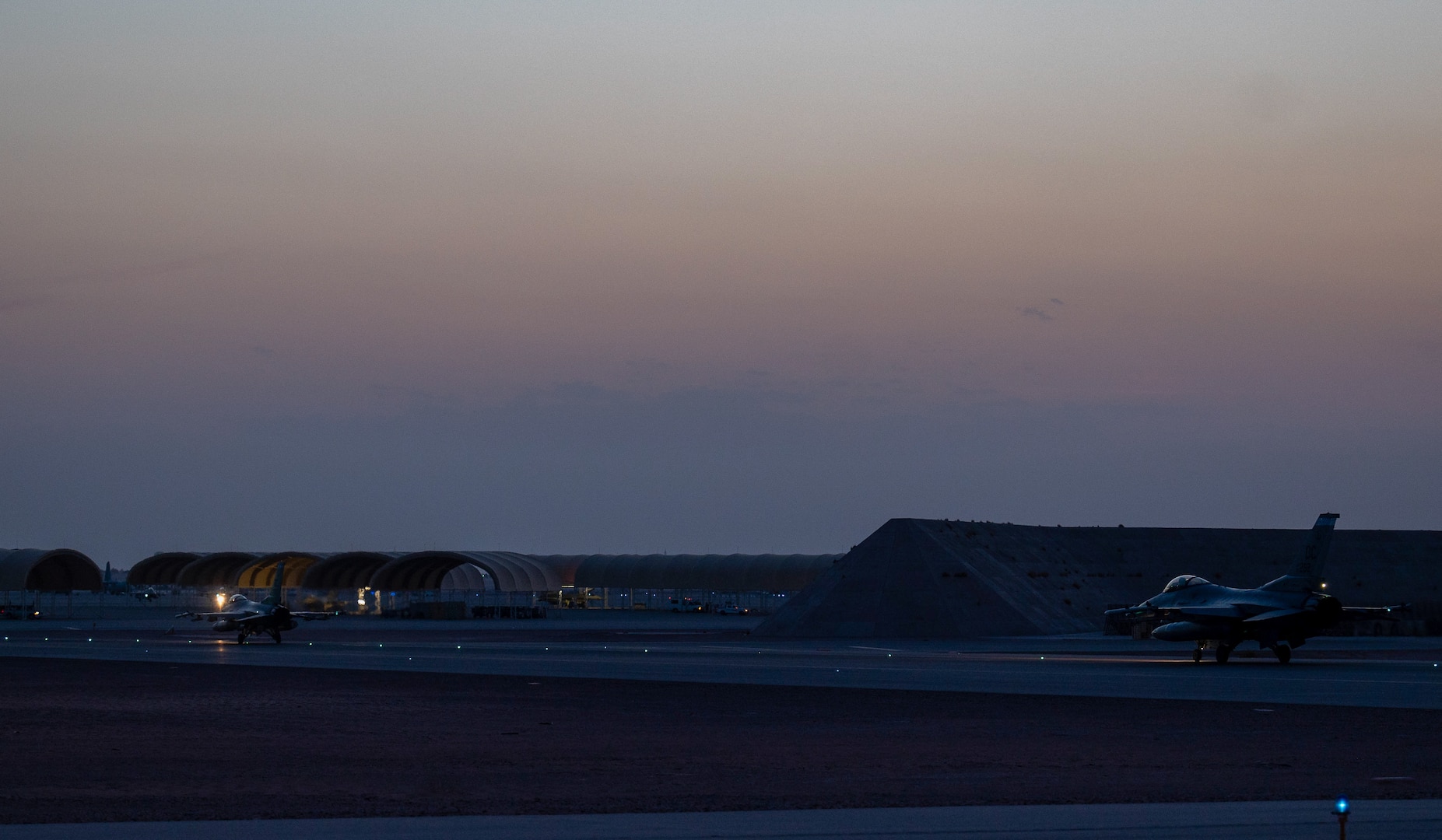 Two U.S. Air Force F-16 Fighting Falcons taxi on the runway at Prince Sultan Air Base, Kingdom of Saudi Arabia, after participating in a combined counter-unmanned aerial systems training operation with Royal Saudi aircraft, July 29, 2021. The event tested the ability of U.S. and Royal Saudi forces to collaboratively track and destroy a simulated invading UAS within regional airspace, continuing to demonstrate the shared focus on the security of regional airspace. (U.S. Air Force photo by Senior Airman Samuel Earick)