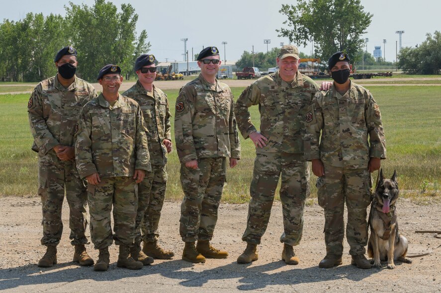 Col. Michael Walters, Commander of the 5th Bomb Wing and Military Working Dog handlers pose for a group picture at Minot Air Force Base, N.D.