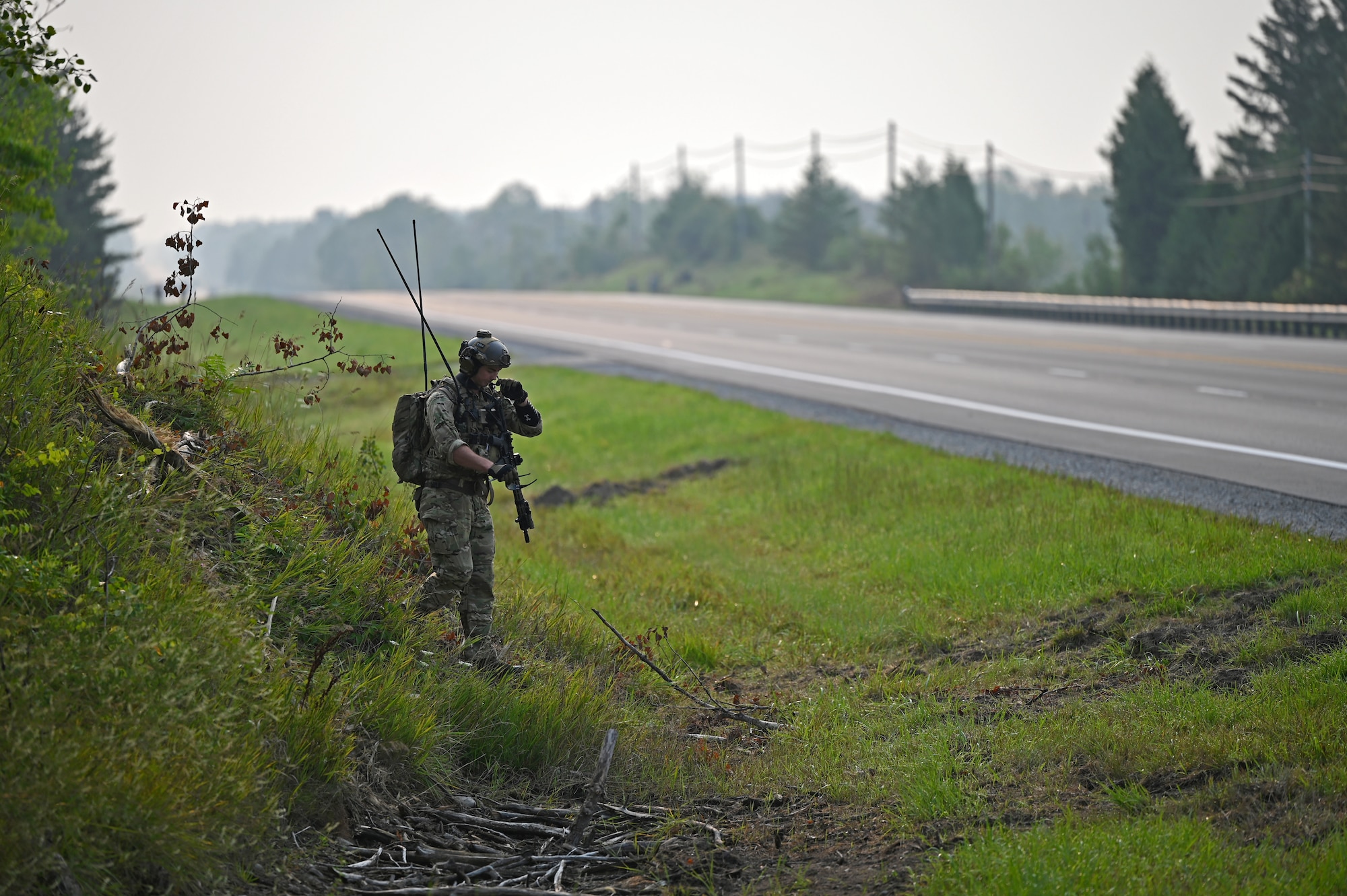 A Special Tactics operator from the 24th Special Operations Wing surveys and prepares a closed section of U.S. Highway 32 in order to land and receive several A-10 Thunderbolt IIs assigned to the 127th and 355th Wings as well as C-146A Wolfhounds assigned to the 492nd and 919th Special Operations Wings during exercise Northern Strike 21 Aug. 5, 2021, in Alpena, Mich. Special Tactics Airmen are the Air Force’s special operations ground force, experienced in conducting global access missions such as establishing austere landing zones around the world.  (U.S. Air Force photo by Staff. Sgt Ridge Shan)