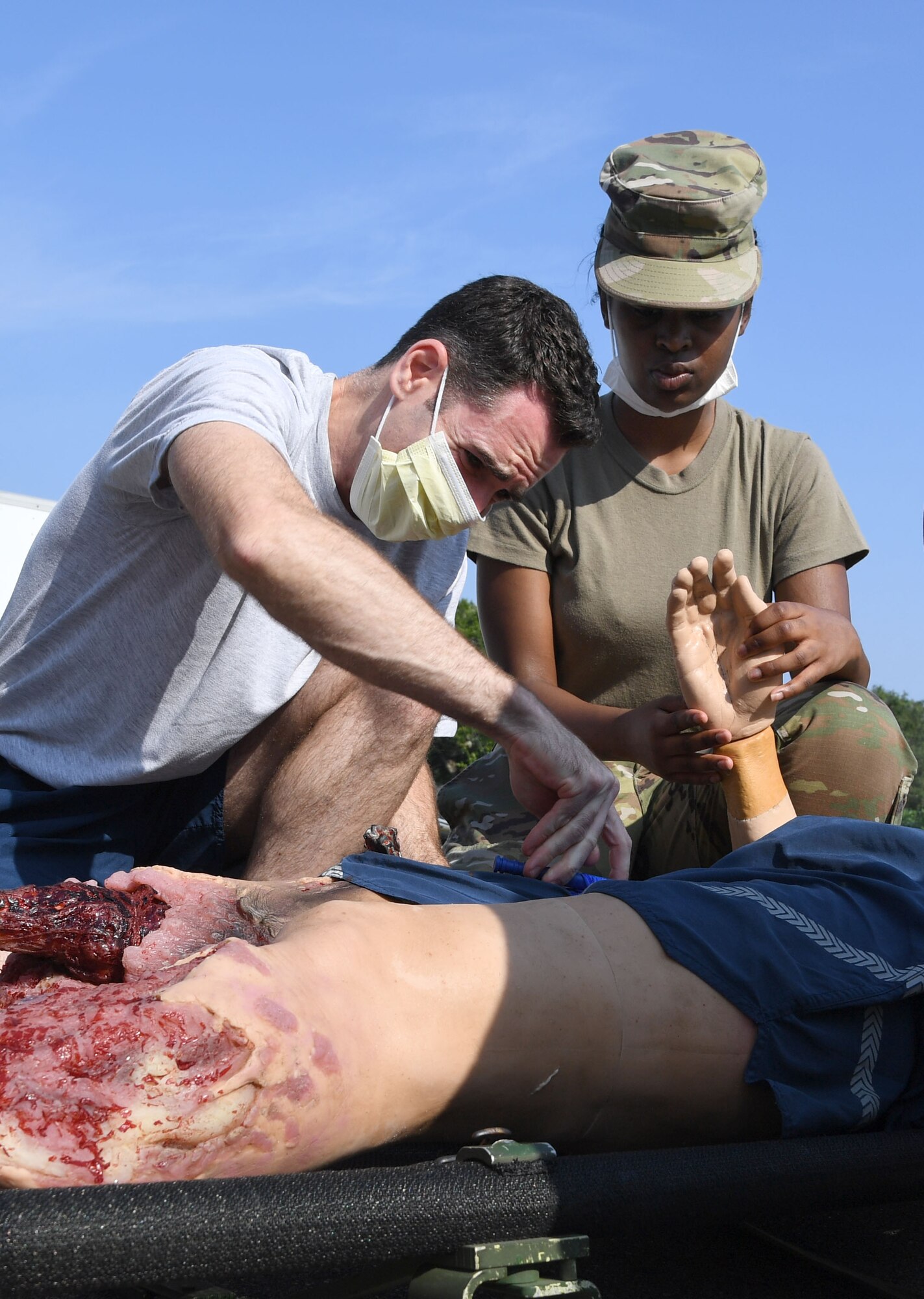 U.S. Air Force Lt. Col. James Renda, 81st Dental Squadron dentist, and Airman 1st Class Heaven Wilborn, 81st Medical Support Squadron medical administrator, applies a tourniquet to a "patient" during a Tactical Combat Casualty Care Rodeo at Keesler Air Force Base, Mississippi, August 5, 2021. The rodeo, a Ready Eagle Training component, provides practical hands-on critical medical trauma skills training for 81st Medical Group personnel. (U.S. Air Force photo by Kemberly Groue)
