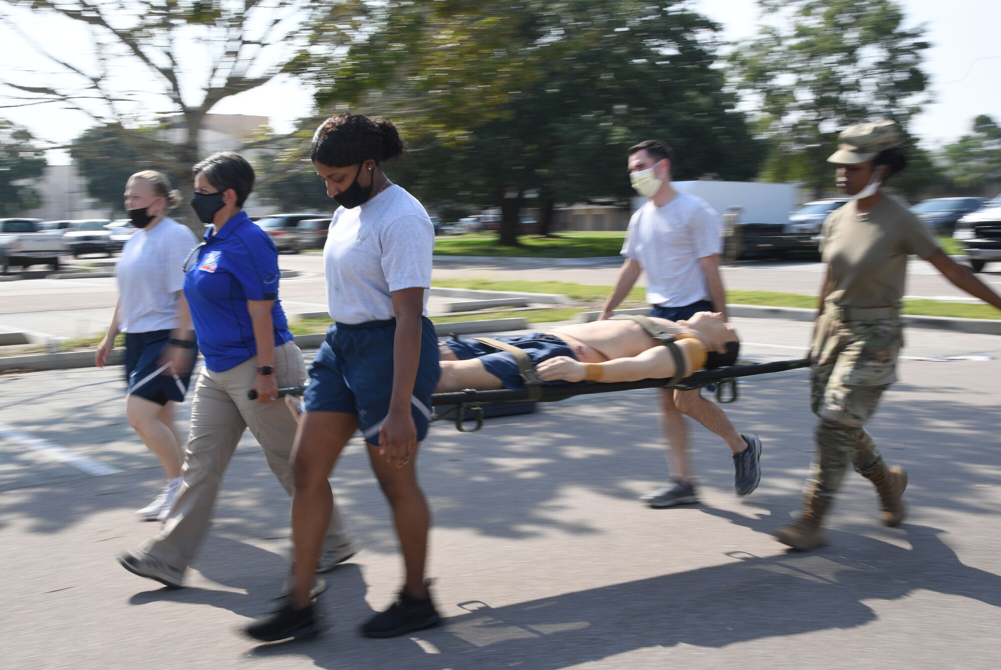 Norma Grandberry, Booz Allen Hamilton medical readiness exercise facilitator, assists members from the 81st Medical Group with a litter carry during a Tactical Combat Casualty Care Rodeo at Keesler Air Force Base, Mississippi, August 5, 2021. The rodeo, a Ready Eagle Training component, provides practical hands-on critical medical trauma skills training for 81st MDG personnel. (U.S. Air Force photo by Kemberly Groue)