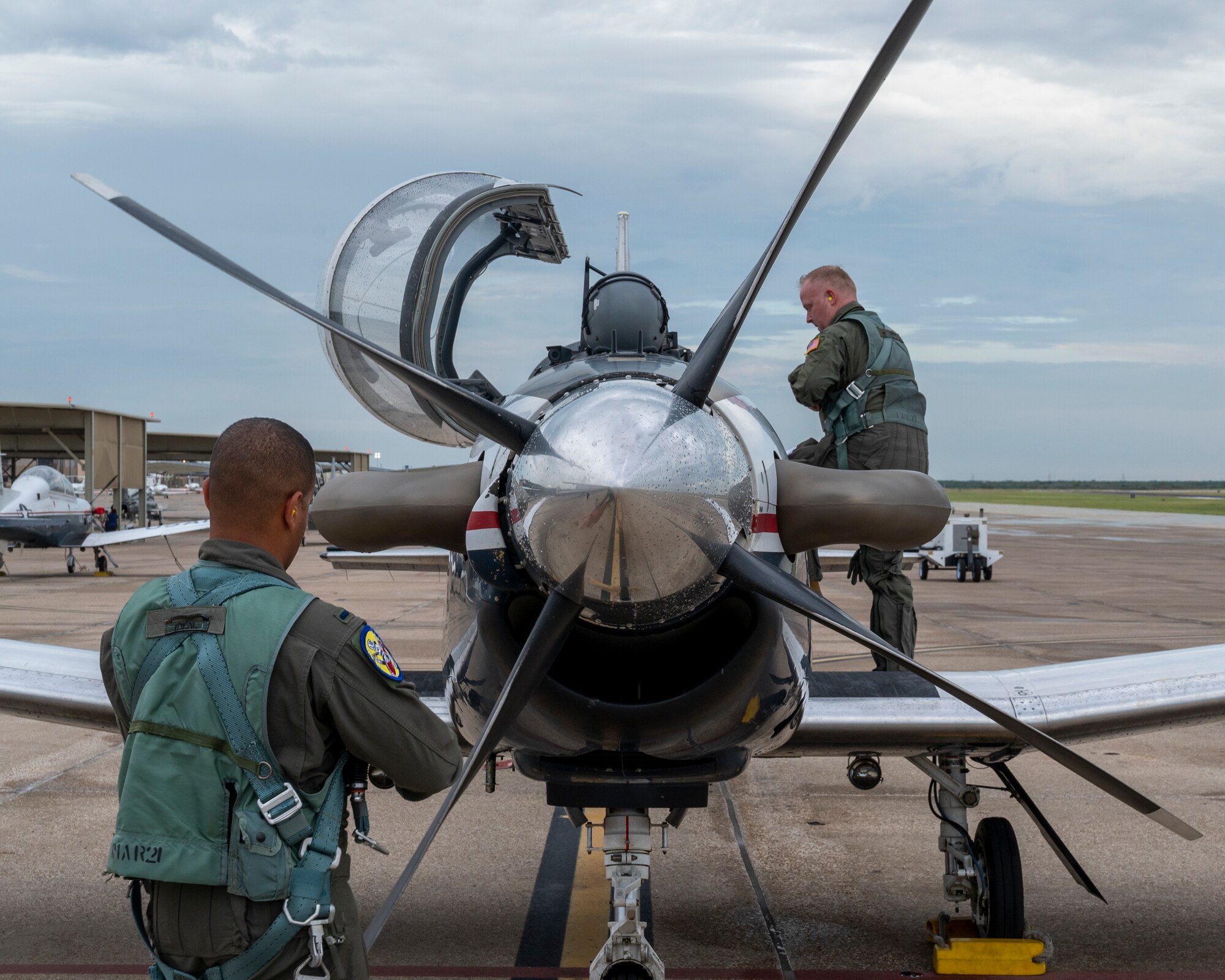 U.S. Air Force 1st Lt. Mike Gadalla, 85th Flying Training Squadron instructor pilot, preforms a pre-flight check while U.S. Air Force  Col. Adam Bingham, 47th Operation Group commander, climbs into the cockpit of a T-6 Texan II at Laughlin Air Force Base, Texas on August 5, 2021. Pilots on Tiger Day took to the sky to celebrate their heritage for being a part of the 85th Flying Training Squadron in a competition against fellow instructor pilots.(U.S. Air Force Photo by Senior Airman Nicholas Larsen)