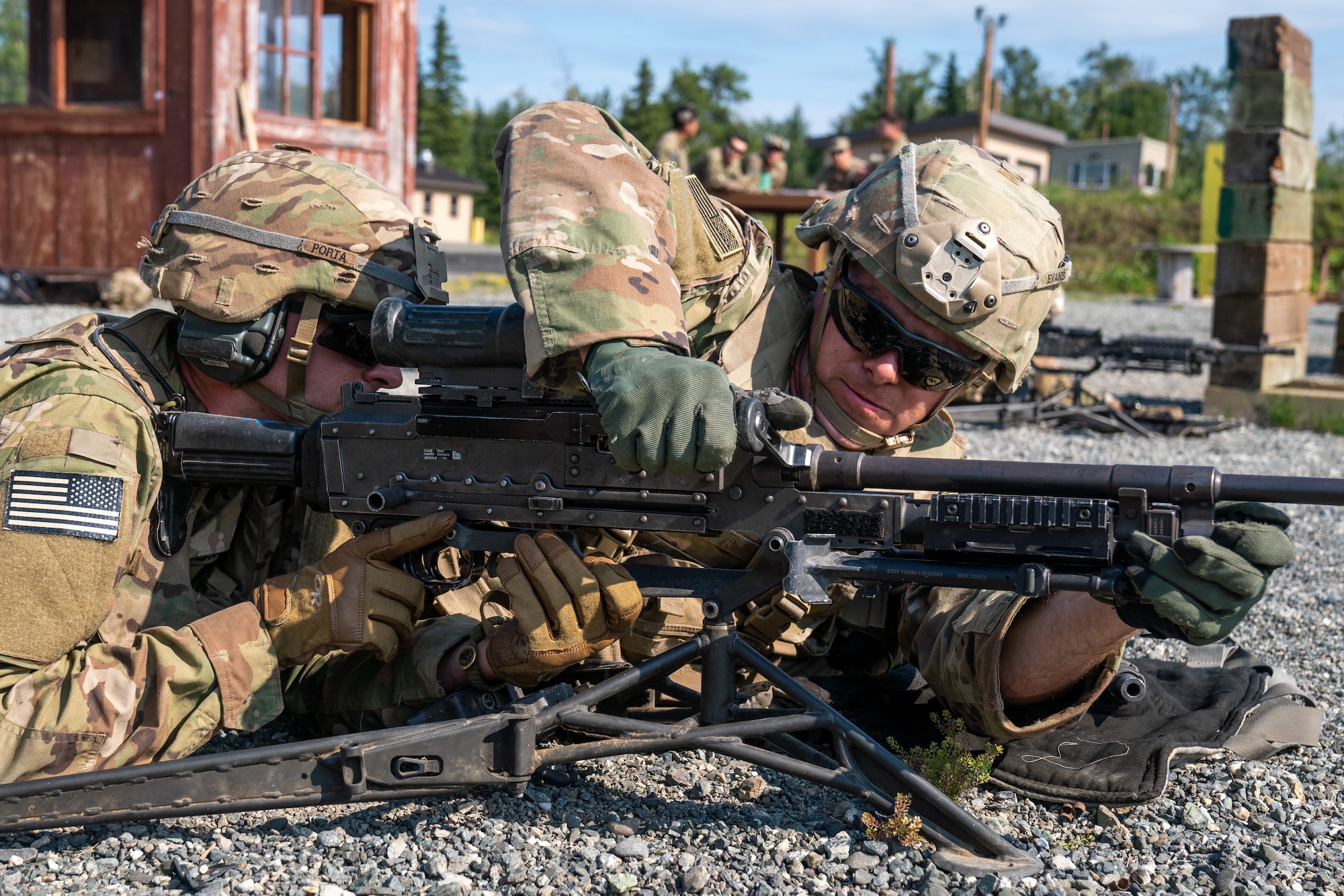 U.S. Army Pfc. Jeremy Porta (left) and Spc. Richard Evans, combat engineers assigned to the 6th Brigade Engineer Battalion (Airborne), 4th Infantry Brigade Combat Team (Airborne), 25th Infantry Division, U.S. Army Alaska, attach the barrel to an M240B machine gun while conducting live-fire training.