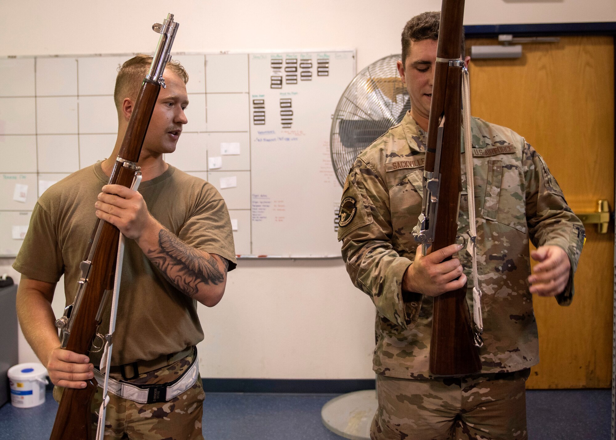 U.S. Air Force Airman 1st Class Dawson Winder, a Joint Base Elmendorf-Richardson Honor Guardsman, teaches an Airman how to hold a rifle during an Honor Guard Open House at JBER, Alaska, July 19, 2021. The Honor Guard hosted the event to encourage Airmen to participate in the Honor Guard program. (U.S. Air Force photo by Senior Airman Emily Farnsworth)