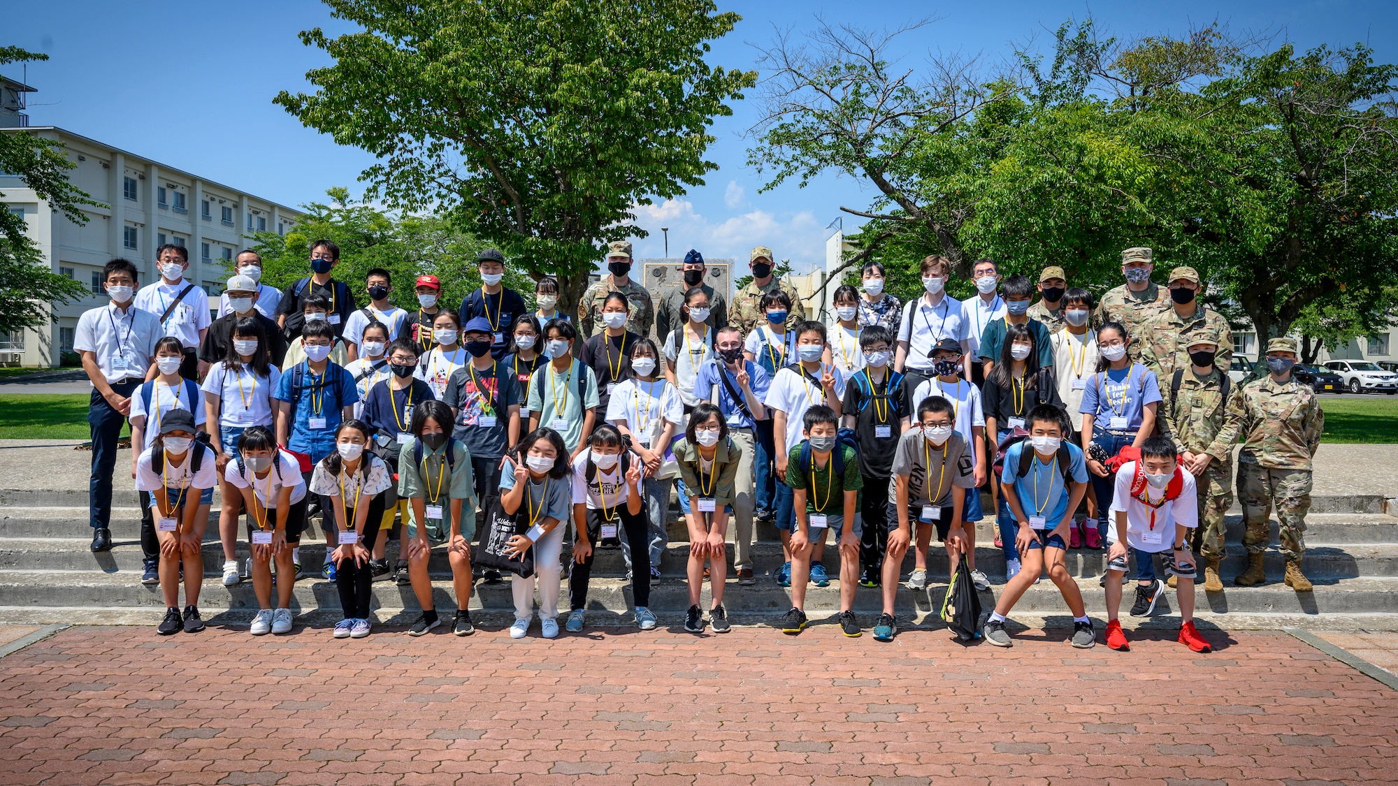 Misawa City English Camp students take a photo with members of Team Misawa during a base tour at Misawa Air Base, Japan, Aug. 3, 2021. During the tour, students interacted with base leadership and were able to ask questions to better understand the Misawa AB mission. (U.S. Air Force photo by Senior Airman China M. Shock)