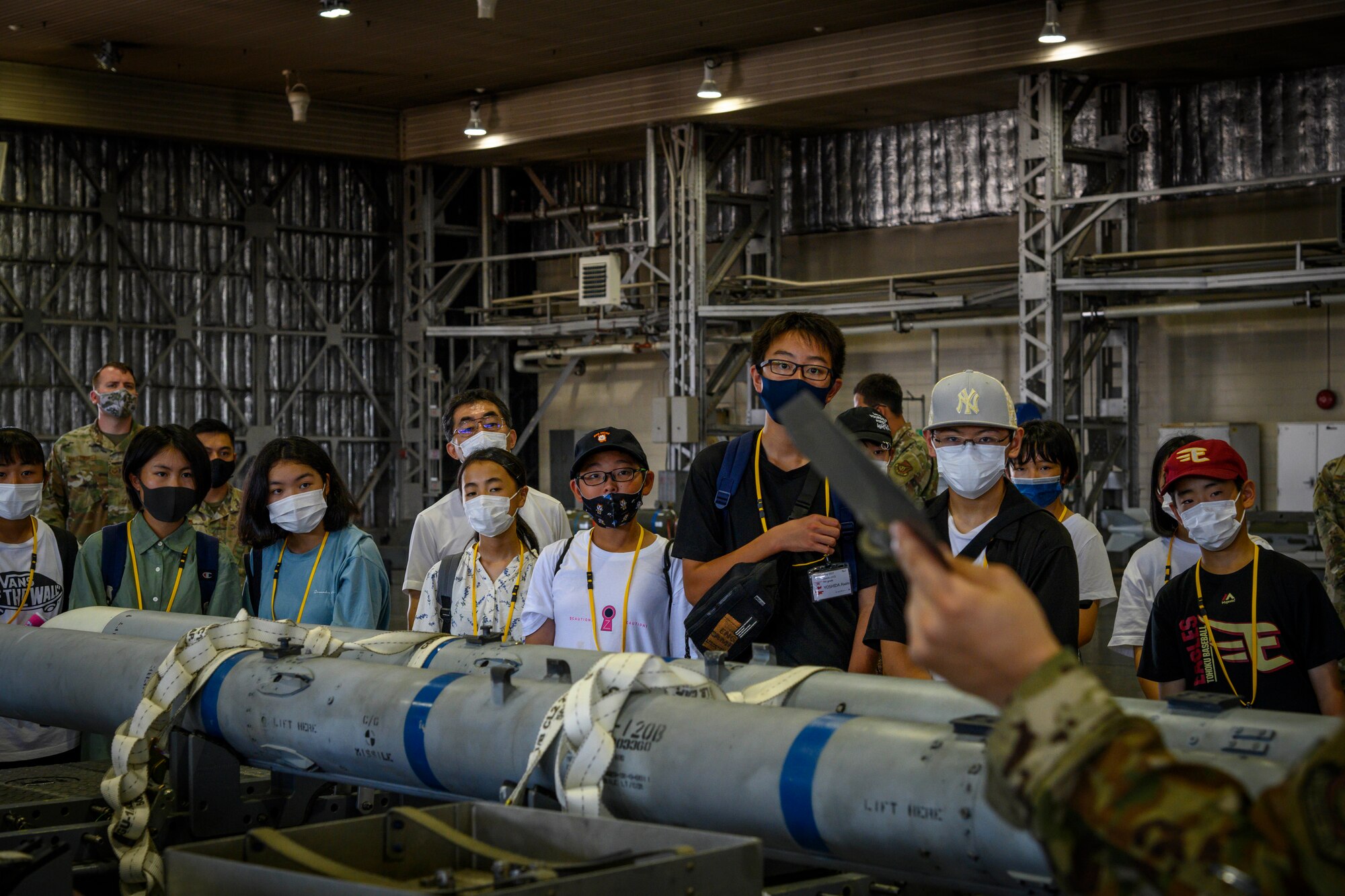 Misawa City English Camp students listen to a briefing during a base tour at Misawa Air Base, Japan, Aug. 3, 2021. The students visited various work centers, including the 35th Fighter Wing headquarters, 35th Force Support Squadron Misawa Teen Center, 35th Civil Engineer Squadron fire station, Naval Air Facility terminal, Commissary and Base Exchange. (U.S. Air Force photo by Senior Airman China M. Shock)