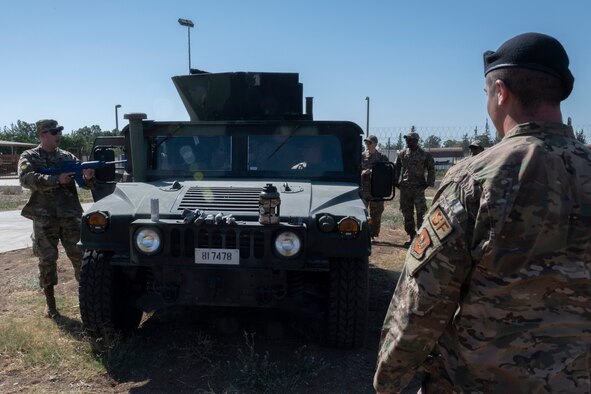 Airmen standing around military vehicle