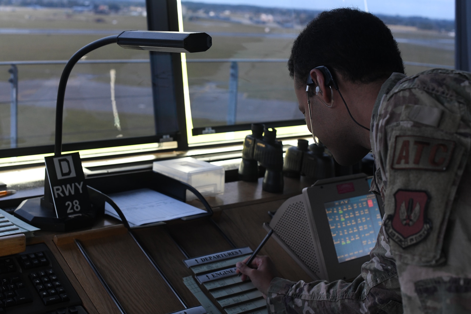 U.S. Senior Airman Malcolm Blair, 100th Operation Support Squadron air traffic controller communicates with an incoming KC-135 Stratotanker aircraft July 28, 2021, at Royal Air Force Mildenhall, England. Controllers communicate with aircrews using a two-way radio system. (U.S. Air Force photo by Senior Airman Antonia Herrera)